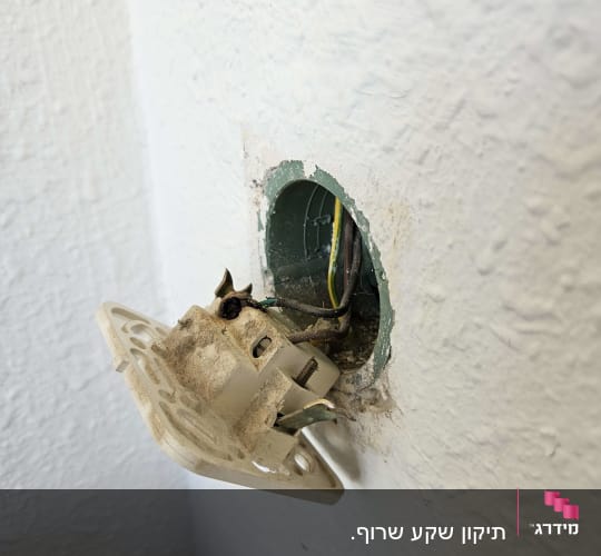 שקע חשמלי פתוח עם חוטים חשופים בקיר